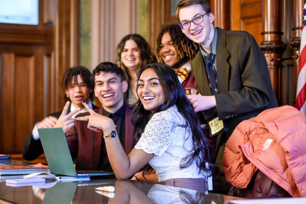 Image of students in the courtroom smiling for the camera