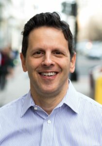 Headshot of a man in striped shirt on the street